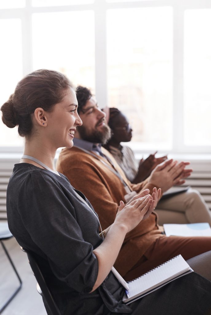 People applauding at a professional development seminar